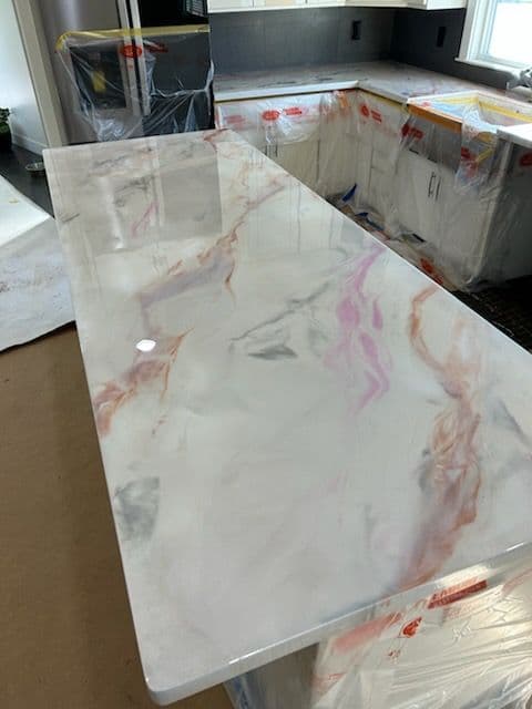 Marble countertop with pink and gray veining, newly installed in a kitchen renovation.